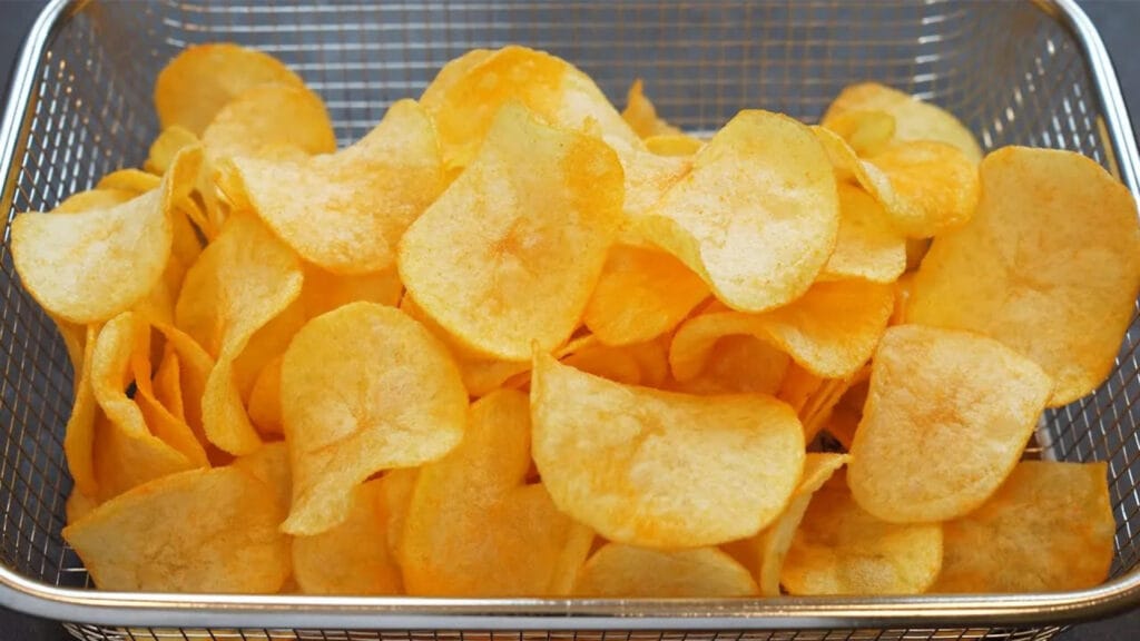 چیپس خانگی ترد و پنیری تازه سرخ شده در سبد فلزی