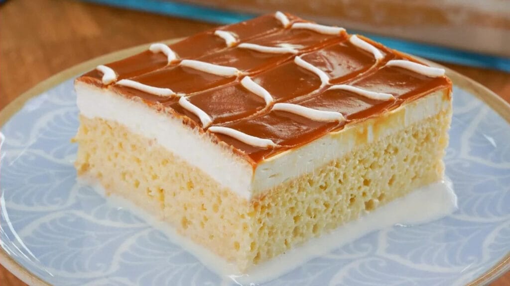 طرز تهیه کیک ترس لچس خانگی؛ تصویر یک برش کیک سه شیر لطیف با رویه کاراملی و خامهای مناسب مهمانی و دسر
