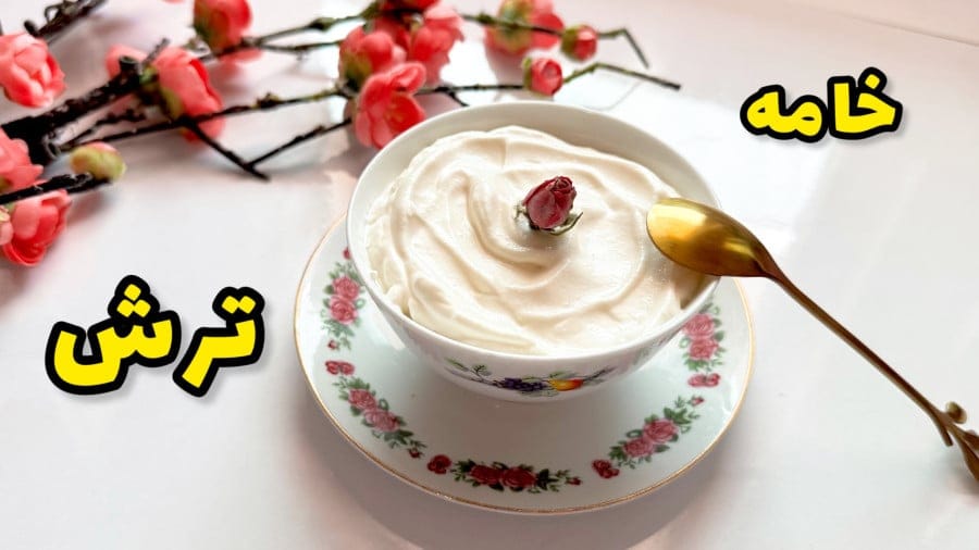 کاسهای از خامه ترش سفید و کرمی با یک غنچه گل رز روی آن.