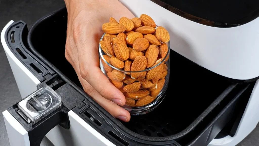 لیوان بادام درختی در حال قرار گرفتن داخل سبد هواپز خانگی سفید