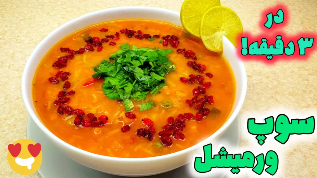 کاسه سفید پر از سوپ ورمیشل داغ و خوشرنگ، تزئین شده با جعفری خرد شده، زرشک قرمز و دو برش لیمو ترش تازه در کنار آن.