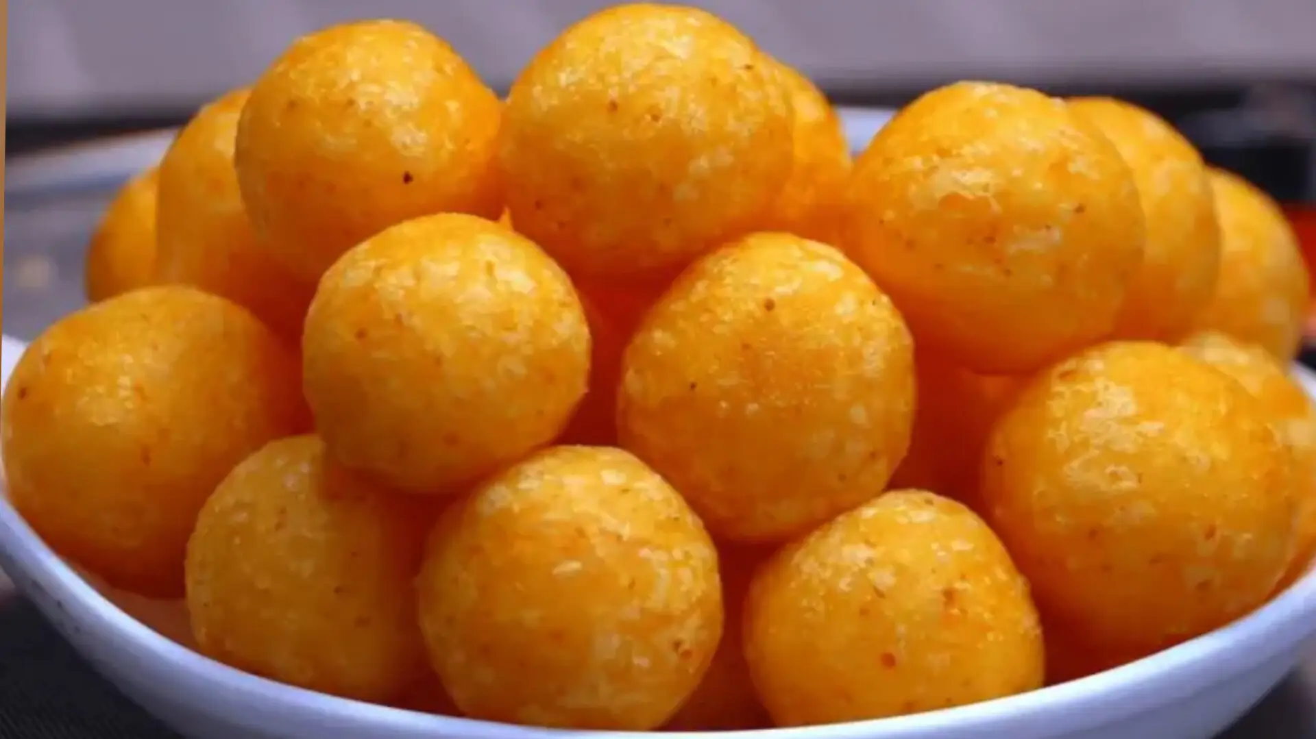 سیبزمینی توپی سوخاری طلایی با بافت ترد و پفکی در بشقاب سفید، لقمههای کوچک خوشمزه مناسب عصرانه و مهمانی