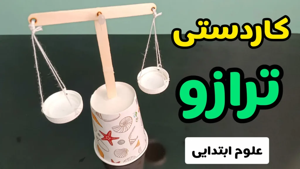 ترازوی کاردستی علمی با چوب بستنی، نخ و درب بطری روی پایه لیوان کاغذی مناسب به عنوان کاردستی مدرسه