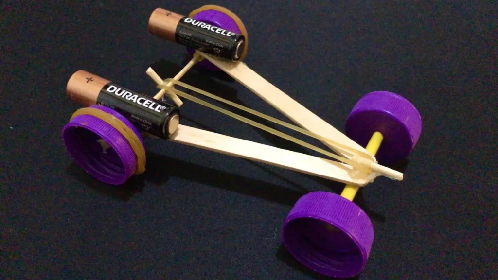 کاردستی ماشین کشی ساخته‌شده با چوب بستنی، درپوش بطری و کش لاستیکی؛ کاردستی برای مدرسه