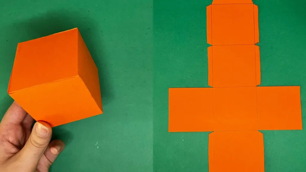 کاردستی مکعب نارنجی ساخته شده از طرح گسترده روی مقوا رنگی ساده