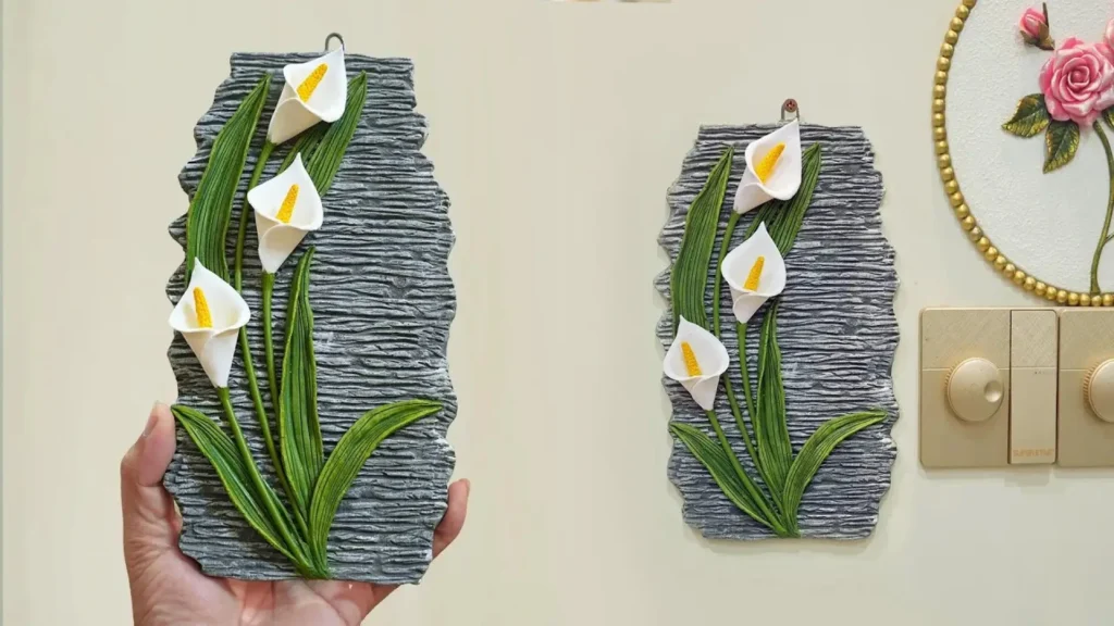 تابلو تزیینی برجسته با طرح گل شیپوری سفید و برگ‌های سبز ساخته شده از گچ روی دیوار