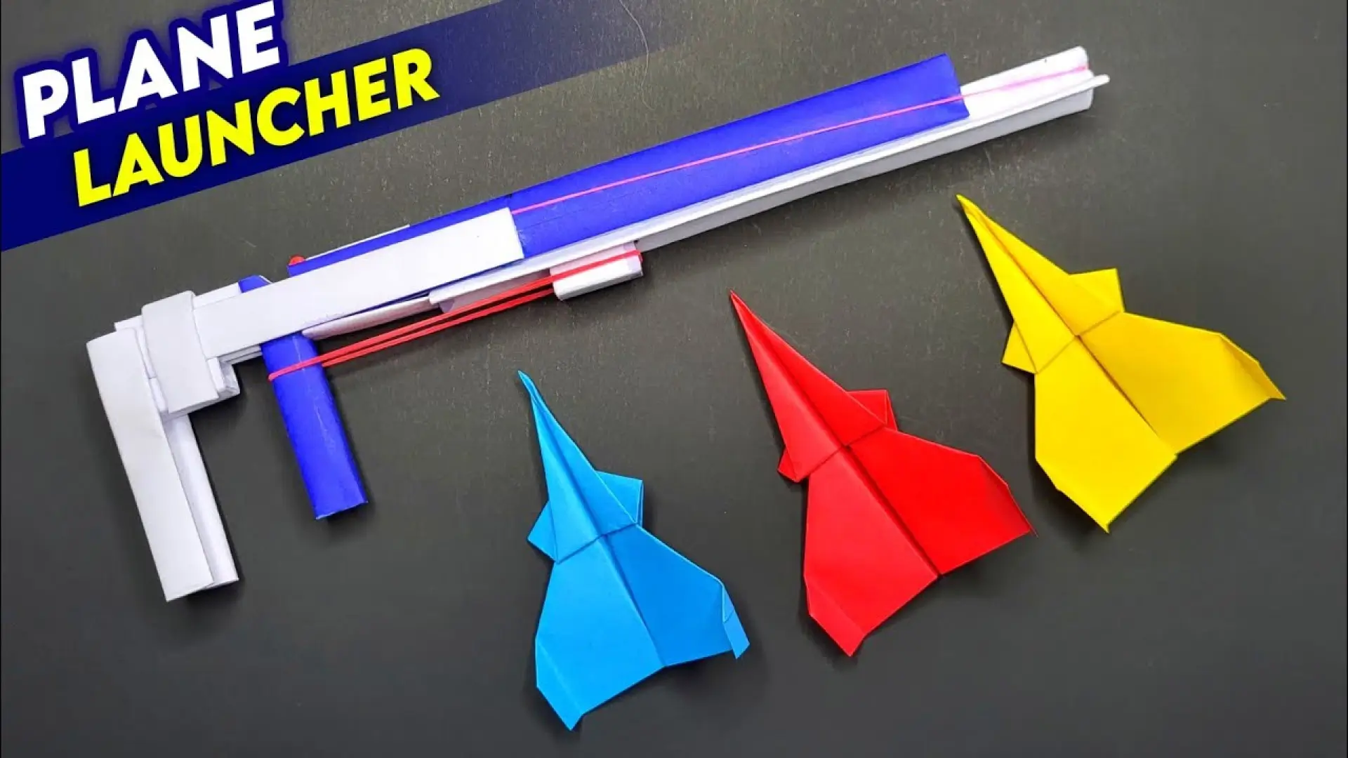 کاردستی تفنگ پرتابگر موشک کاغذی (Plane Launcher) ساخته شده با لوله‌های کاغذی و کش به همراه سه هواپیمای اوریگامی رنگی