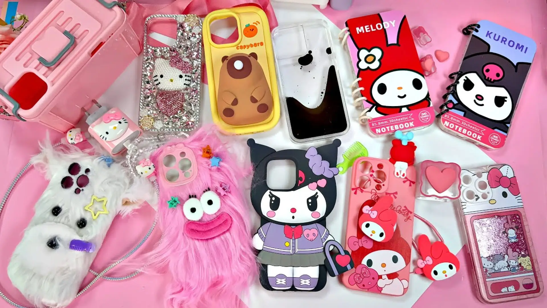 مجموعه متنوع قاب گوشی فانتزی دخترانه طرح هلو کیتی و کورومی و مدلهای پشمالو روی میز صورتی