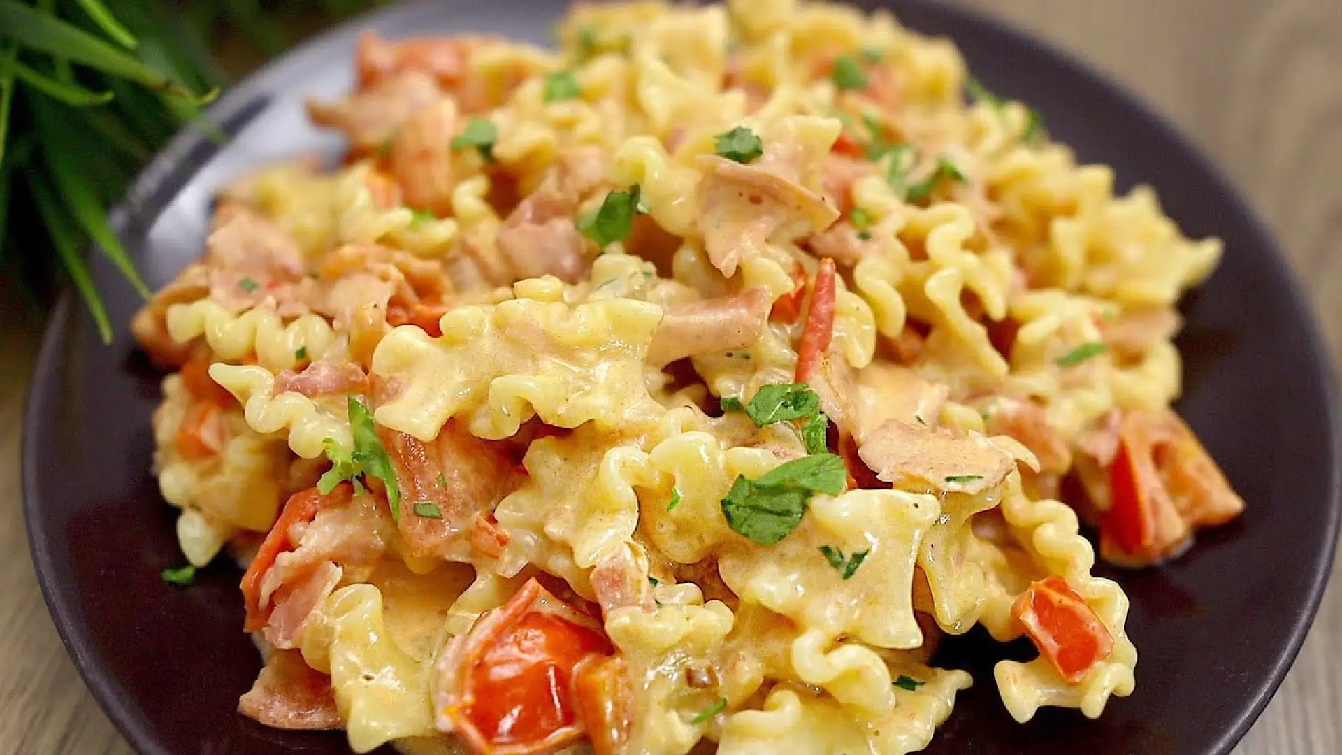 بشقاب پاستا فرمی با سس آلفردو غلیظ، تکه‌های ژامبون سرخ شده و جعفری خرد شده