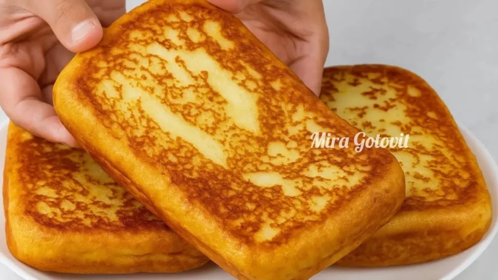 دو قطعه کوکوی سیب زمینی و پنیر پیتزا به شکل مستطیل ضخیم که رویه‌ای کاملاً طلایی و برشته دارد و در یک بشقاب سفید سرو شده است.