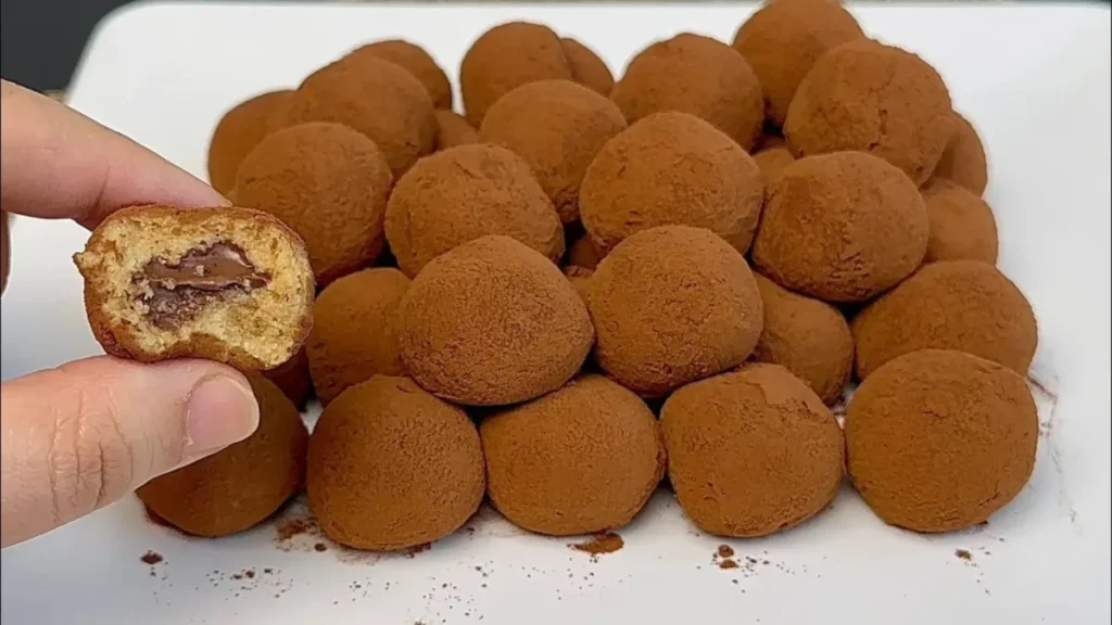 توپکهای تیرامیسو با روکش پودر کاکائو و بافت بیسکویتی مرطوب در بشقاب سفید به همراه نمای برش خورده دسر