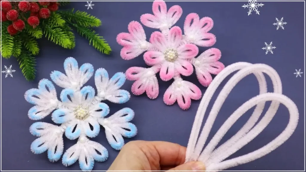 ساخت دانه برفی با پیپ پاک کن برای تزیین شب یلدا، کاردستی زمستانی با سیم پرزدار، آویز برفی صورتی و آبی، ایده دکوراسیون زمستانی دست‌ساز.