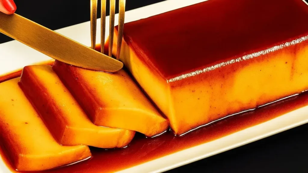 دسر ایتالیایی موزی کاراملی با بافتی نرم و لطیف، برش‌خورده با لایه براق سس کارامل روی ظرف سفید