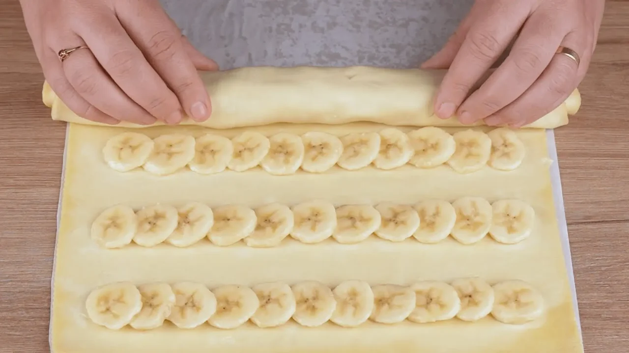 مراحل پیچیدن خمیر هزارلا روی اسلایسهای موز برای تهیه شیرینی رولی