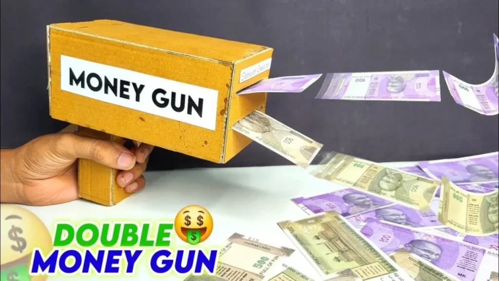 دست در حال استفاده از تفنگ پول پاش دست‌ساز مقوایی زرد رنگ که دو ردیف اسکناس ساختگی را به هوا پرتاب می‌کند.